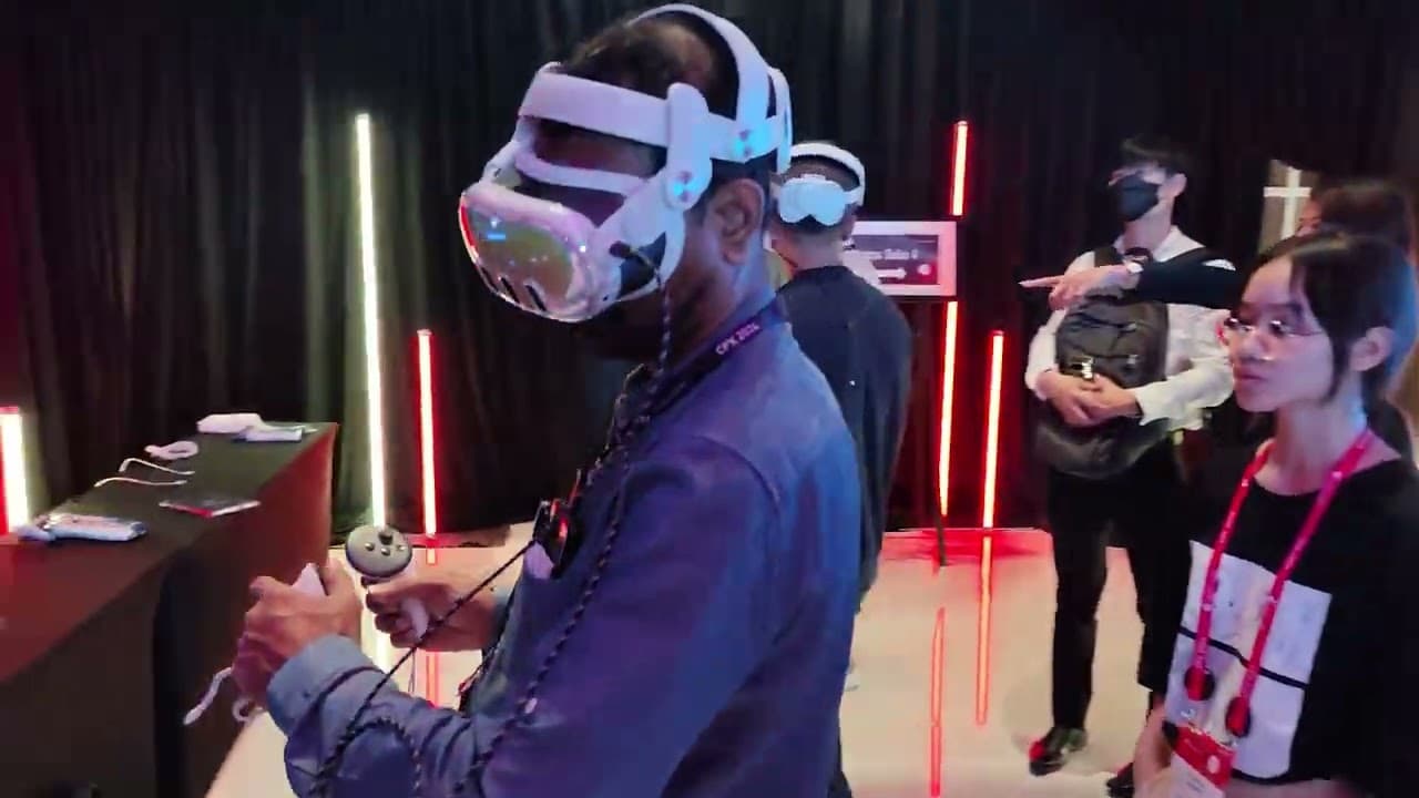 A CPX 2024 attendee using a VR headset and controllers, with event staff nearby.