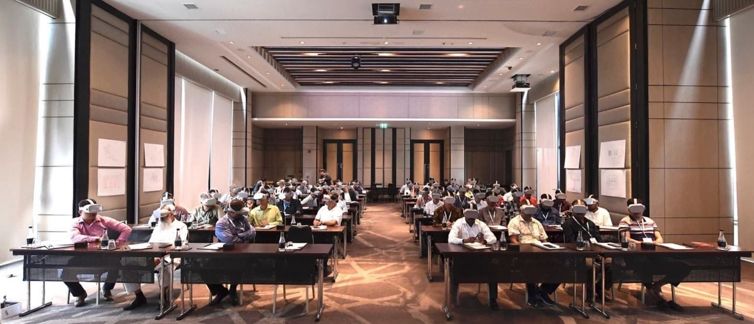An Aviagen event audience wearing VR headsets during a group viewing session.