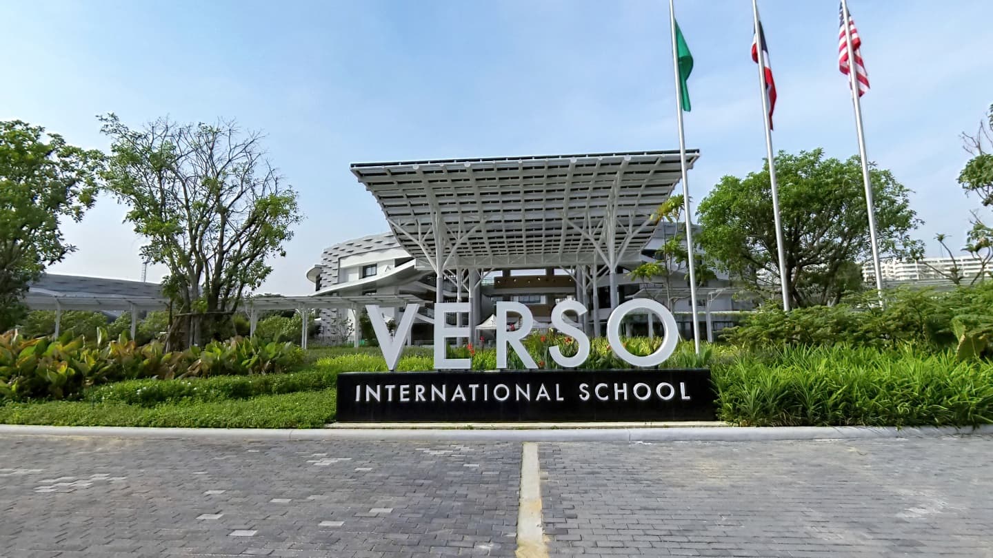 VERSO International School entrance sign with landscaped grounds and flags