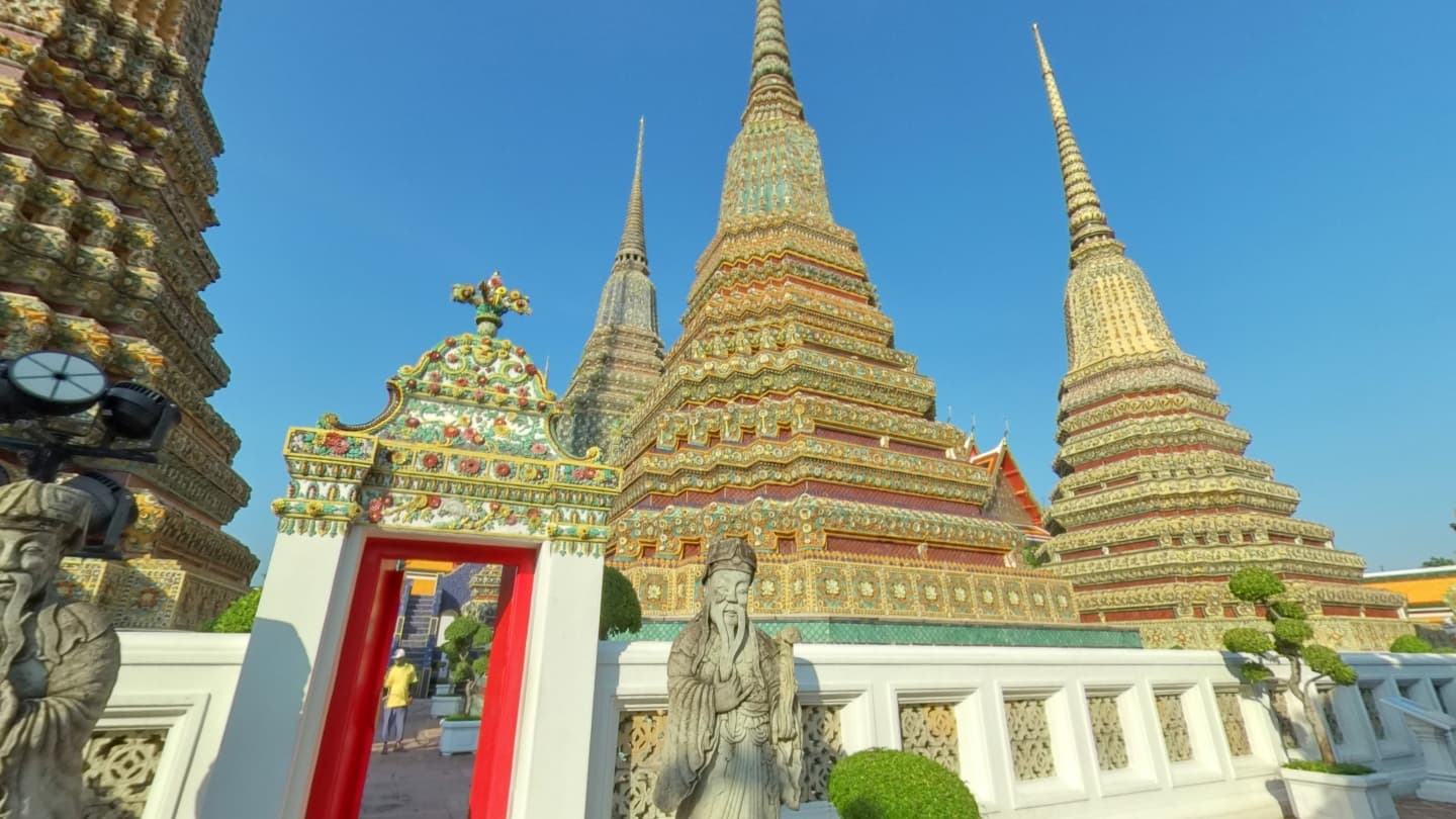 Ornately tiled temple spires at Wat Pho against a blue sky