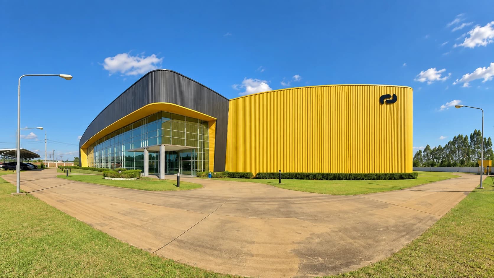 Yellow facade and glass entrance of an Alcami industrial facility