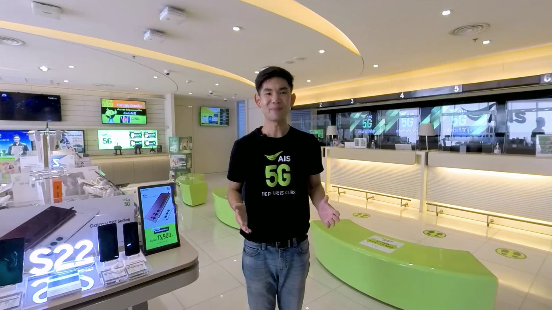 An AIS presenter introducing customer-service VR training inside an AIS shop.
